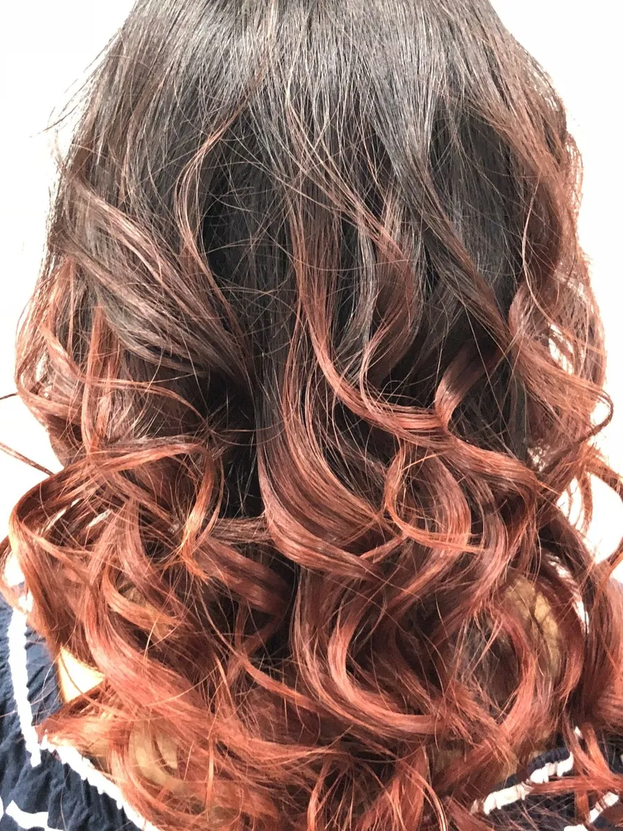 Dark to copper red balayage with curly waves at DC Hair Lounge